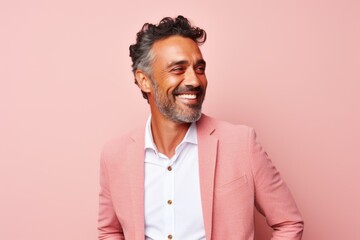 Obraz premium Portrait of a handsome middle-aged Indian man in a pink suit on a pink background