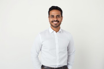 Fototapeta premium Portrait of a handsome young indian man smiling at camera over white background
