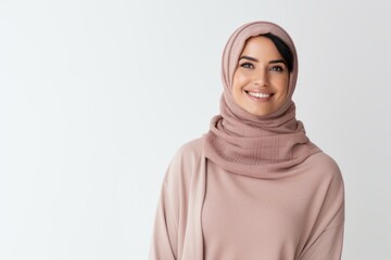 cheerful young muslim woman in hijab looking at camera isolated on white