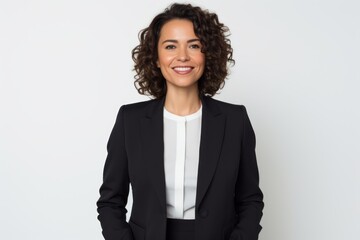 Portrait of a smiling businesswoman standing with hands in pockets over white background
