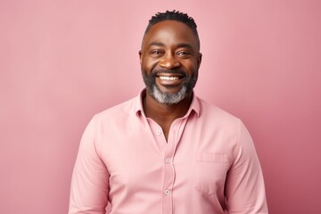 Obraz premium Portrait of a smiling african american man with beard looking at camera isolated over pink background