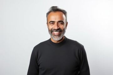 Obraz premium Portrait of a smiling middle-aged Indian man standing against white background