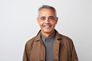 Fototapeta premium Portrait of a smiling middle-aged Indian man in brown jacket
