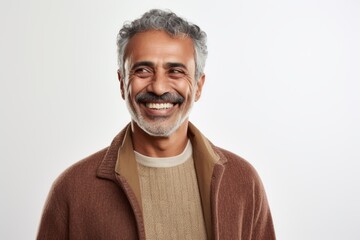 Portrait of happy mature Indian man smiling at camera over white background