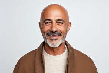 Portrait of a handsome mature man smiling at the camera while standing against white background