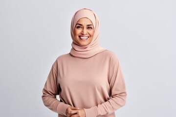 Fototapeta premium happy muslim woman in hijab looking at camera isolated on grey background