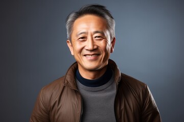 Fototapeta premium asian senior man wearing brown jacket, smiling and looking at camera