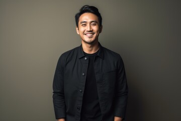 Obraz premium Portrait of handsome asian man in black shirt on grey background
