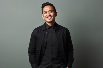 Obraz premium Portrait of a happy young asian man standing against grey background
