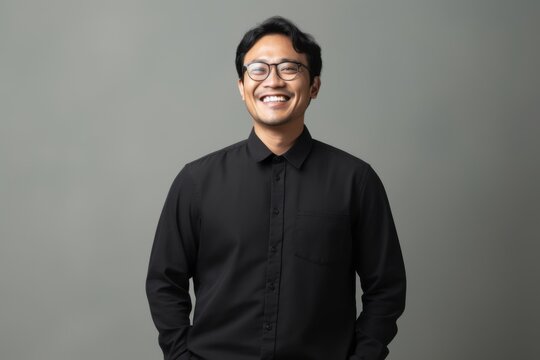 Portrait Of Happy Asian Man In Black Shirt On Grey Background