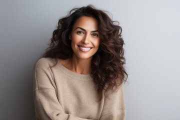 Fototapeta premium Portrait of beautiful woman with long curly hair smiling at camera.