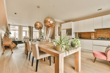 a kitchen and dining area in a modern apartment with wood floors, white cabinets, pink chairs and...