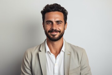 Portrait of a handsome young man smiling at camera against grey background
