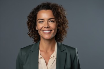 portrait of smiling businesswoman with curly hair, isolated on grey