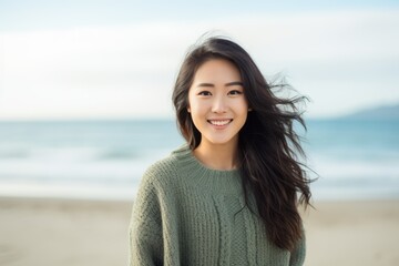 Portrait of beautiful young asian woman smiling and looking at camera on the beach