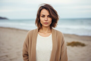 Portrait of a beautiful young woman on the beach in autumn.