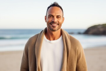 Portrait of handsome man with coat on the beach at the day time