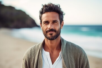 Portrait of handsome man looking at camera at beach during sunny day