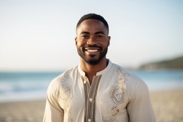 Portrait of a smiling young man standing on the beach at the day time