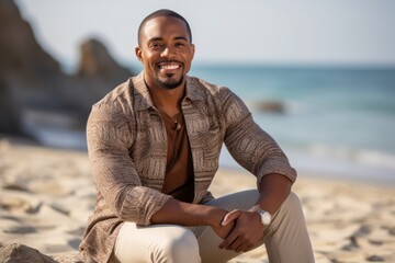 Portrait of smiling african american man sitting on sandy beach