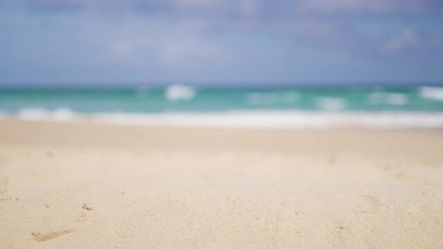 Sand beach blurred island background. Close-up white sandy desert golden clean. Sea wave blue sky. 