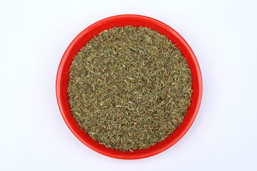 Dried thyme leaves in a plate on white background top view 
