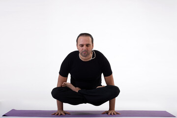 Man doing yoga in photo studio on isolated white background.