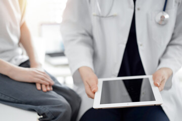 Doctor and child patient. The doctor is using tablet computer and is ready to examine the boy. The concept of ideal health in medicine