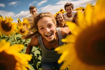 Gardinen Happy group of teens running and laughing in a field of sunflowers © Stephen