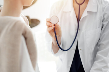 Doctor and a kid patient. Physician is holding stethoscope and ready to examine boy. Perfect health concept in medicine