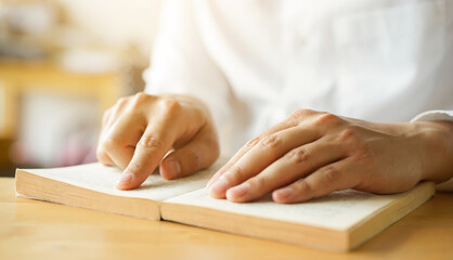 close up young man hand open bible book and reading sentence and worship in the church for hope an religion of christian concept