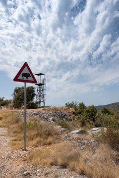 Road sign with attention to wild boar with an observation tower behind in Croatia.