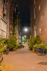 Fototapeta na wymiar Narrow Street of Amsterdam at Night and Several Bicycles