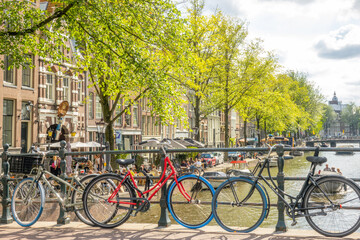 Fototapeta na wymiar Bikes on the Amsterdam Canal Bridge and Waterfront Cafe