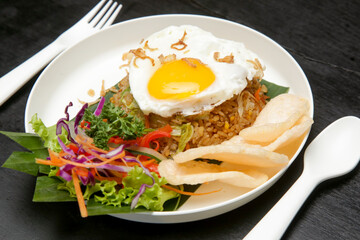 Fried egg served with rice and green salad, asian style breakfast in cafe