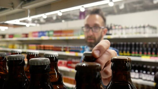A man chooses beer in alcohol department