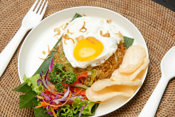 Fried egg served with rice and green salad, asian style breakfast in cafe