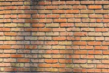 Obraz premium old red brick wall texture background. brightly lit red brick backdrop with copy space. outdoors