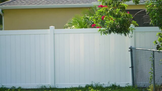 White vinyl fence surrounding private property grounds for backyard protection and privacy in southern Florida