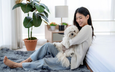 Beautiful young woman spends her free time on holiday having fun playing with her cute pet.