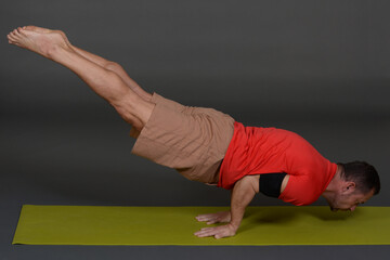 Naklejka premium Man doing yoga in photo studio on isolated background. 