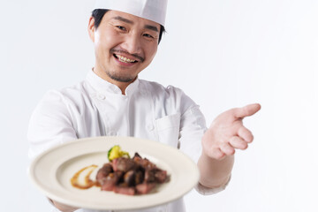 A middle-aged man in a chef's suit serves a delicious meal