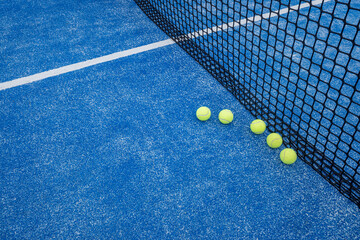 paddle tennis court net blue with five balls