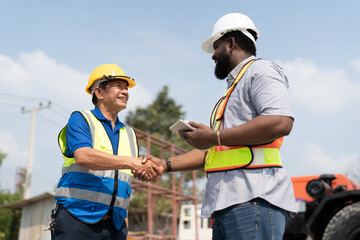 Asian Senior man supervisor foreman handshake with African American engineer for agreement rent...