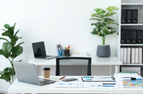 Workspace image. There are laptops, calculators, graphs, documents, folders, folders, stationery, mobile phones used for business work on the office table.