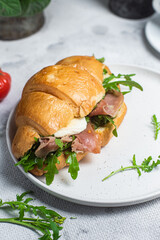 Croissant with jamon, mozzarella and arugula on a plate
