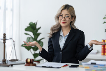 Businesswoman, lawyer, legal consultant wearing glasses in suit sitting at work With paperwork, business contracts, insurance, real estate project agreements in chapters on desk at office.