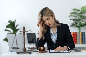 Businesswoman, lawyer, legal counsel sitting at work Tired and stressed with business contract paperwork, insurance, real estate project agreements on office desk.