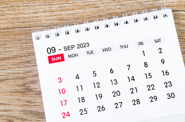 The September 2023 desk calendar for 2023 on wooden background.