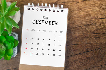 The December 2023 desk calendar for 2023 on wooden background. - obrazy, fototapety, plakaty